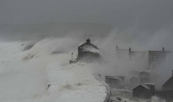 Huge waves approach the three-storey Cove House Inn at Chesil Beach in Dorset © KNS News http://www.sell-story.co.uk/